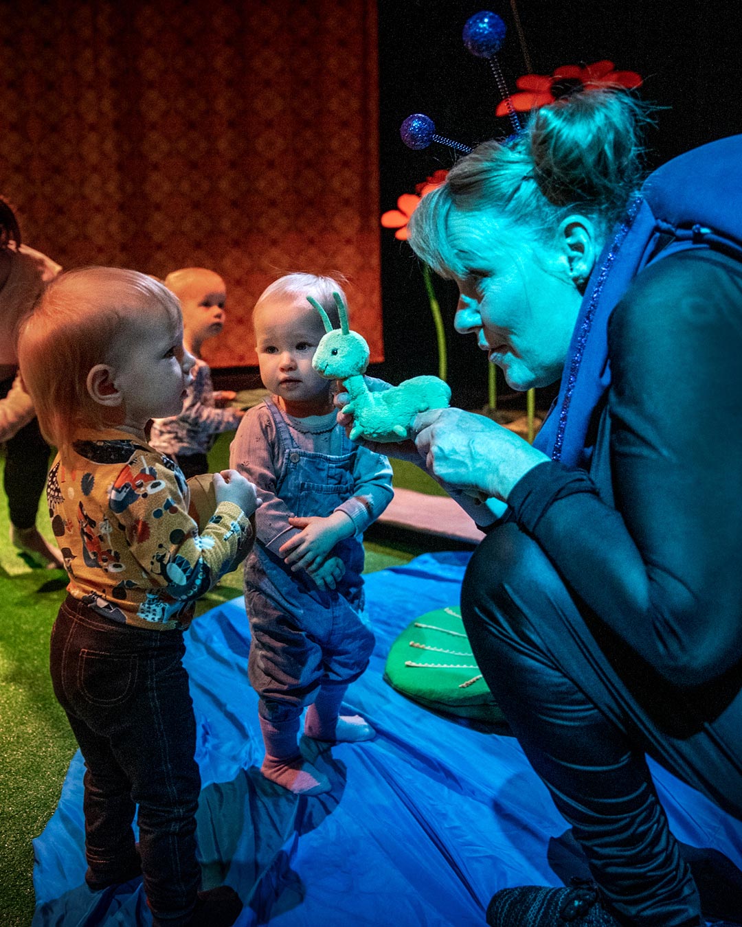 En skådespelare låter barnen runtomkring hälsa på ett mjukisdjur som är en snigel