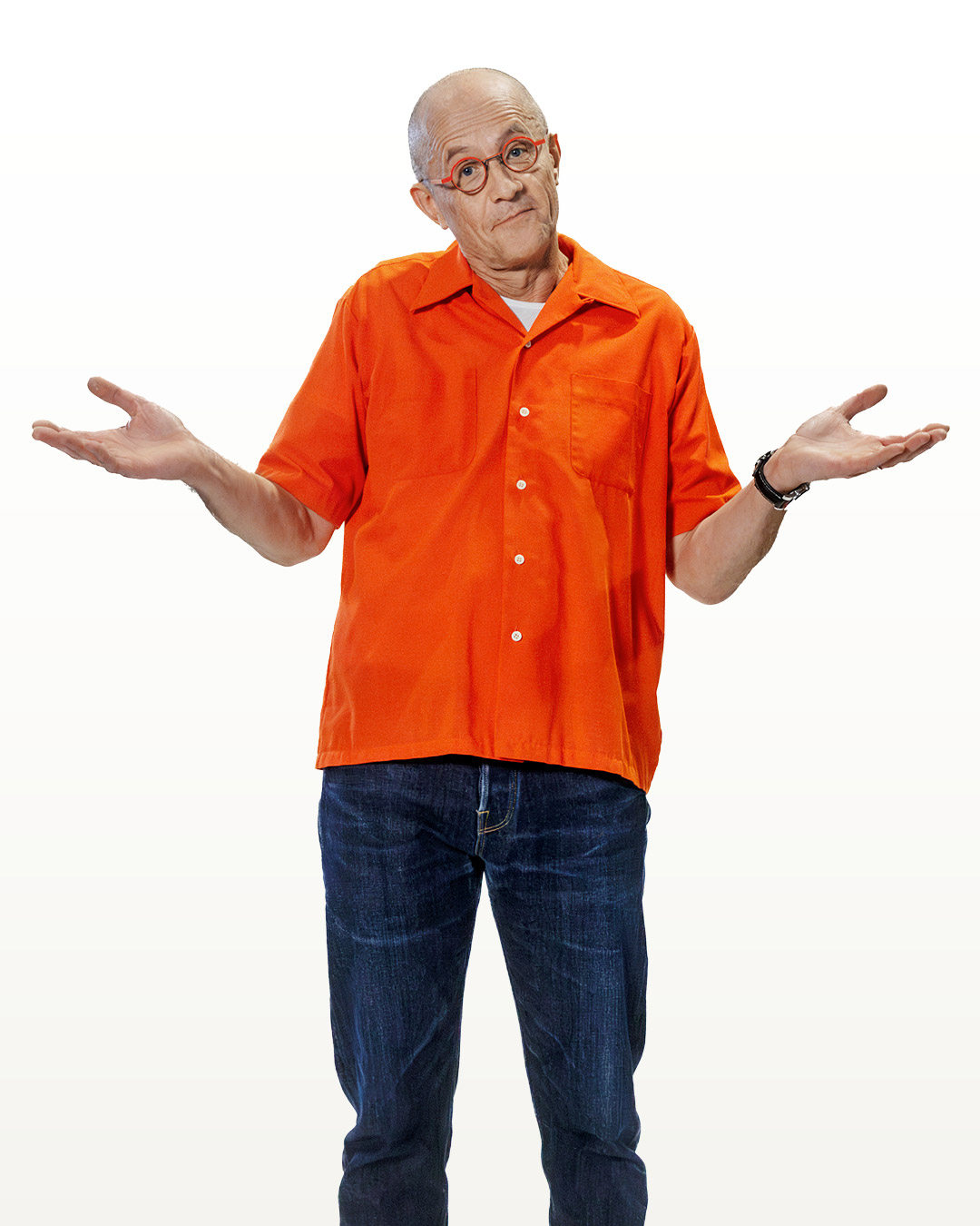 En man klädd o orange skjorta ser frågande ut med armarna lyfta.