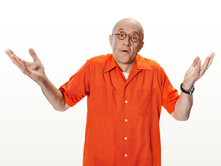 En man klädd o orange skjorta ser frågande ut med armarna lyfta.