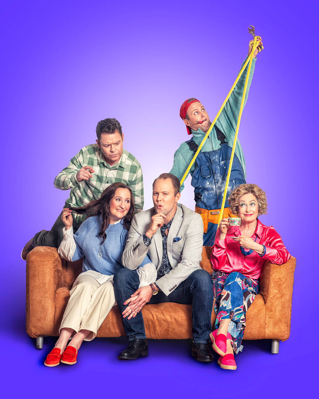 Skådespelarna för repertoaren En lysande idé sitter på en soffa tillsammans. Ett kärlekspar, en man med ett fundersamt ansiktsuttryck, en kvinna som dricker kaffe och en man med verktyg.